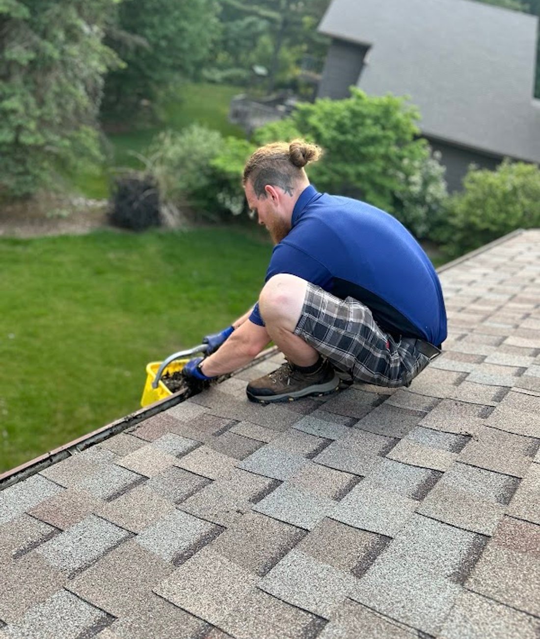 A Godvision Cleaning technician working along a roofline, Battle Creek, Michigan